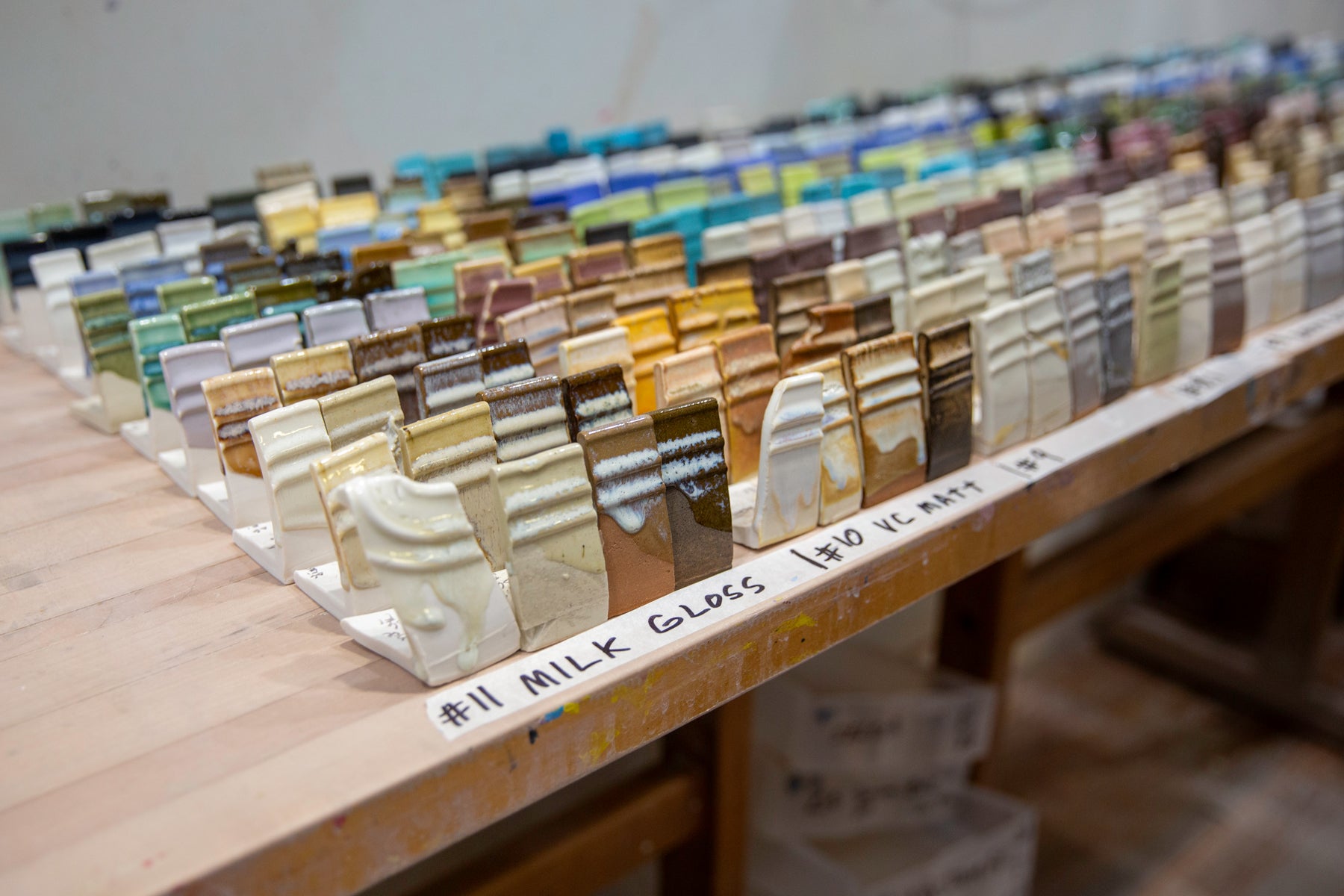 Rows of ceramic test tiles on a table with labels