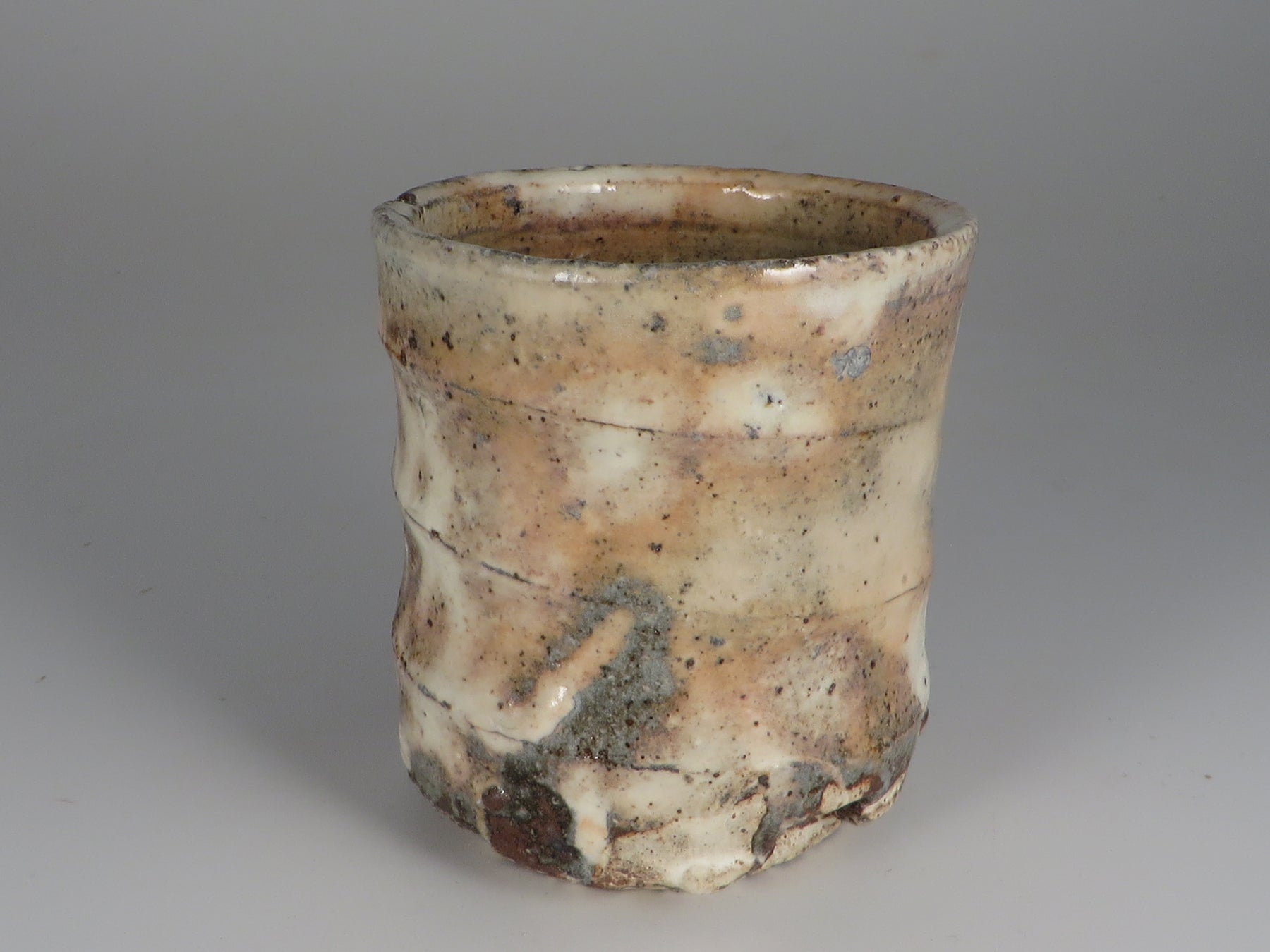 A ceramic cup with a textured Gohonde surface on a gray background