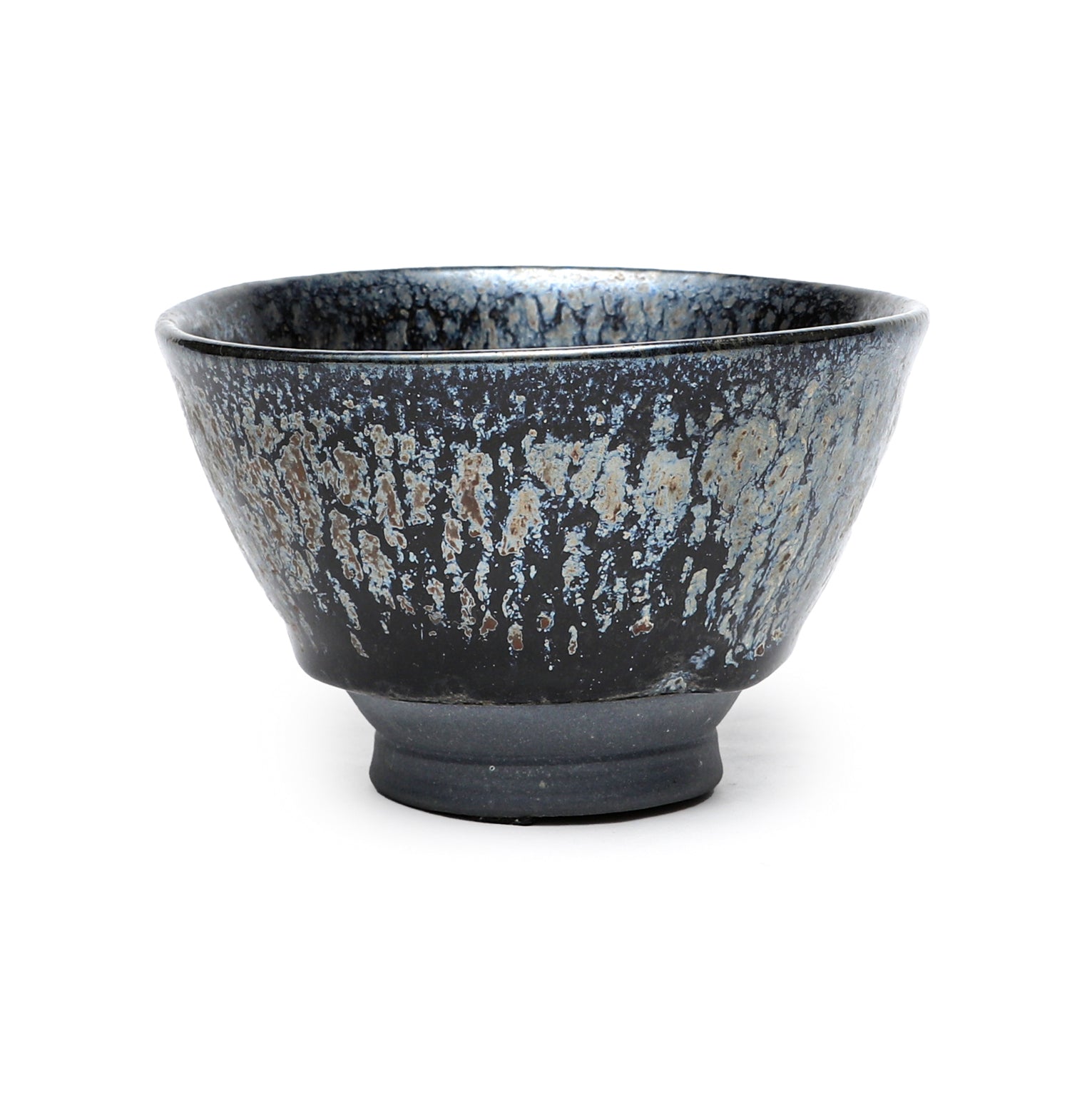 A John Britt black ceramic bowl with speckled kind of drippy pattern on a white background